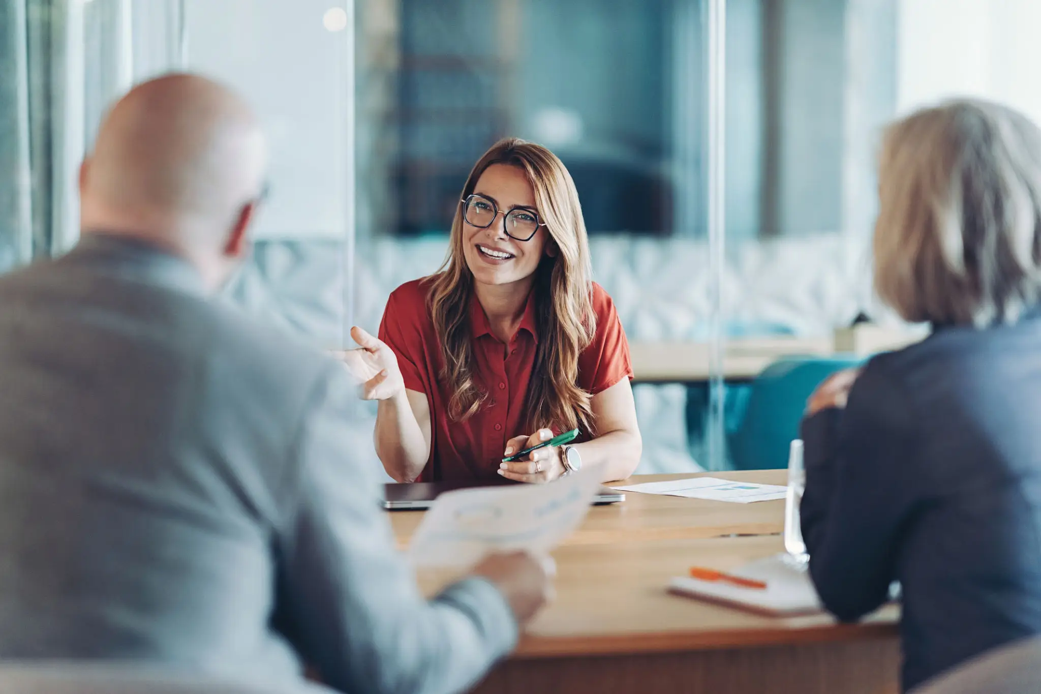 Young woman smiling and talking in a meeting.